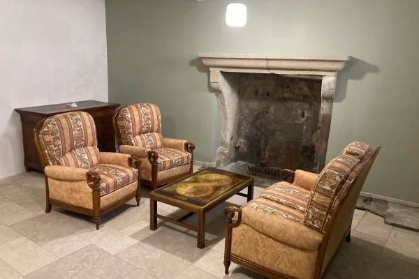 Salon du gîte Maison Stendhal aux Échelles en Savoie avec fauteuils et cheminée en pierre