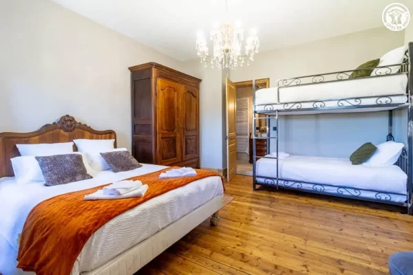 Chambre - Gîte Maison Stendhal - Chartreuse Lit double et lits superposés du gîte Maison Stendhal aux Echelles en Savoie avec linge de lit blanc